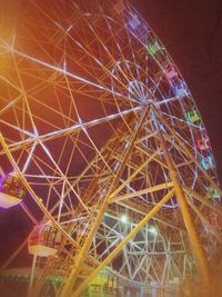 Low angle view of illuminated ferris wheel against sky at night