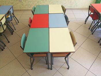 High angle view of tables and chairs on tiled floor in kindergarten