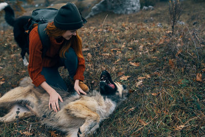 Full length of woman with dog on field