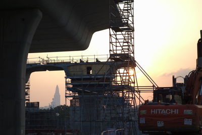 Low angle view of construction site against sky during sunset