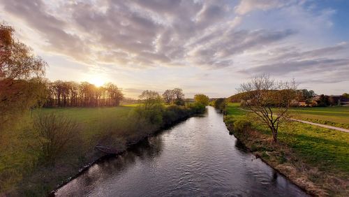 Scenic view of river against sky during sunset