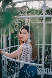 Portrait of young woman standing in greenhouse