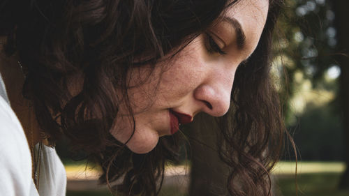 Close-up portrait of young woman looking down