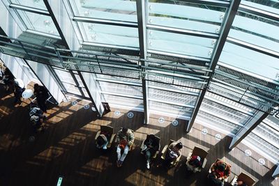 High angle view of people sitting on chairs at lobby