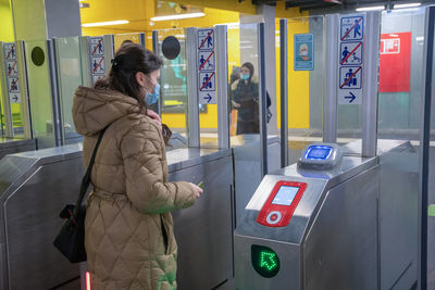 Brussels belgium-01.31.2022 young woman in mask scans a card at in the subway