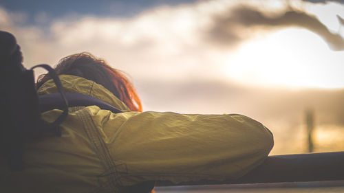 Low angle view of man sitting against sky