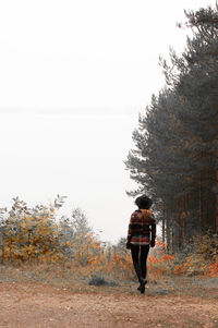 Rear view of young woman walking in forest