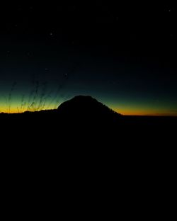 Silhouette mountain against sky at night