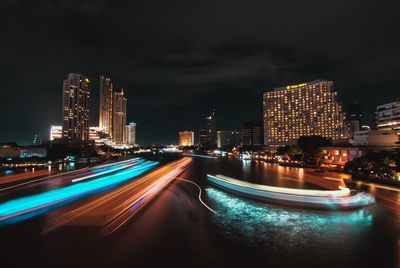 Light trails on illuminated city buildings at night