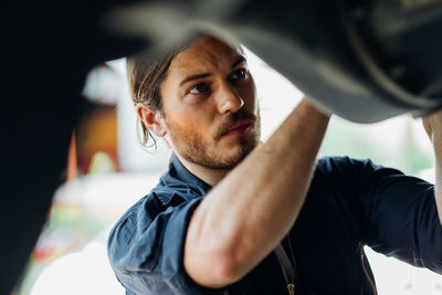 Close-up of mechanic working in garage