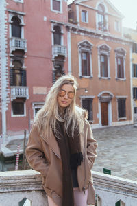 Woman standing on bridge against buildings