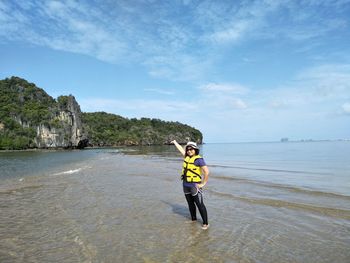 Woman standing on shore against sea at beach