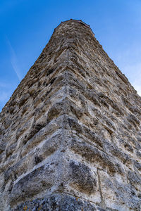 Low angle view of stone wall against sky