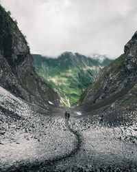 Person on mountain against sky