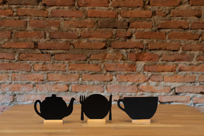 Close-up of black coffee on table against brick wall