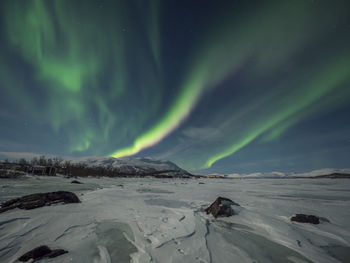 Scenic view of frozen landscape against sky at night