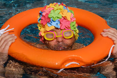 Portrait of man with life belt in swimming pool