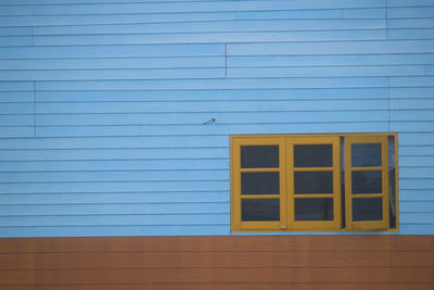 Closed blue wall and windows of building