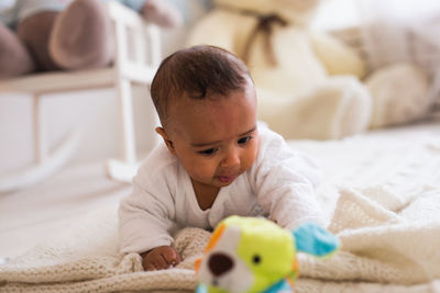 Cute boy lying down on bed at home