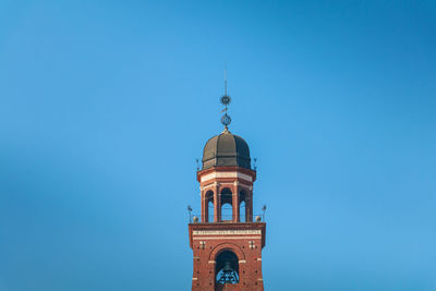 Low angle view of tower of building against blue sky
