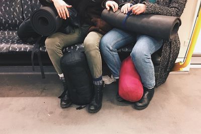 Low section of women sitting with luggage in metro train