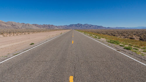 Road amidst desert against clear sky