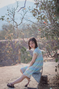 Portrait of woman sitting against trees