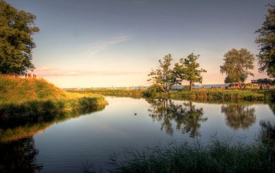 Scenic view of lake against sky at sunset