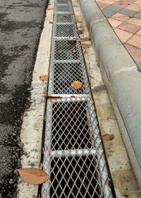 High angle view of metal grate on road
