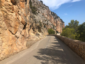 Road amidst rock formation against sky