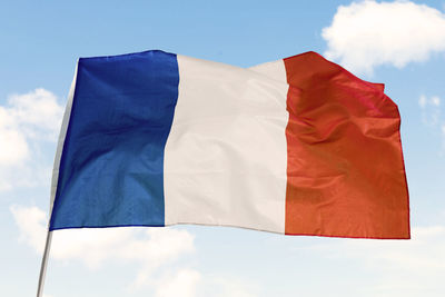 Low angle view of flag against blue sky