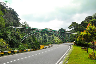 Road amidst trees against sky