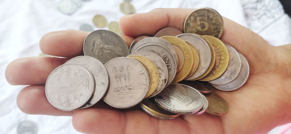 Close-up of hand holding coins