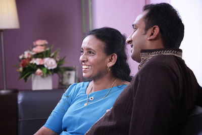 Side view of a smiling woman sitting on floor