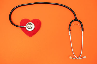 Close-up of heart shape against orange background