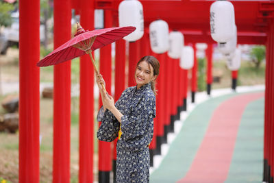 Portrait of a young woman with red umbrella