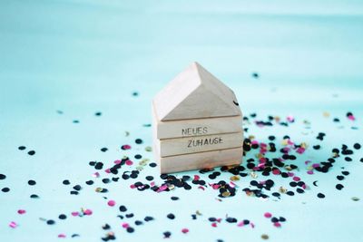 Wooden block with text amidst colorful confetti