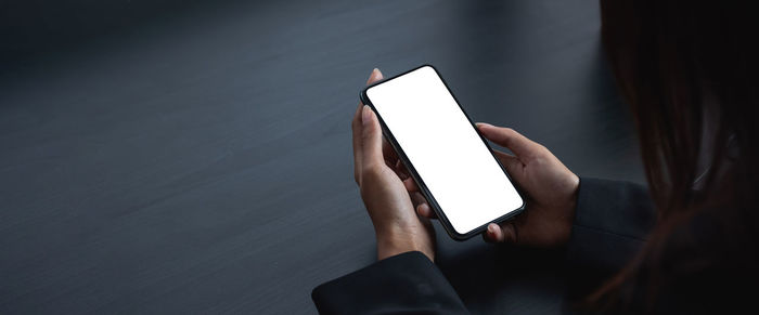 Low angle view of woman holding mobile phone