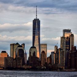 Modern buildings in city against cloudy sky