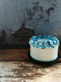 Close-up of cake on table against white wall