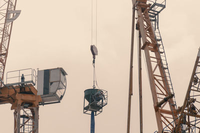 Low angle view of cranes against sky