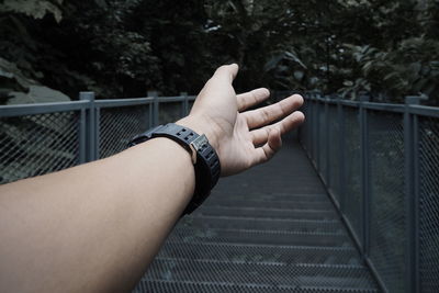 Cropped image of man hand on footbridge