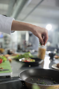 Cropped hand of chef preparing food