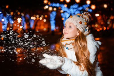 Portrait of smiling woman in snow at night