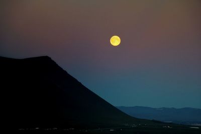 Scenic view of silhouette mountains against clear sky at night