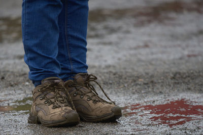 Low section of person wearing shoes standing on street