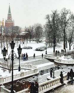 People on snow covered city against clear sky