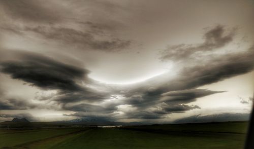 Scenic view of field against cloudy sky