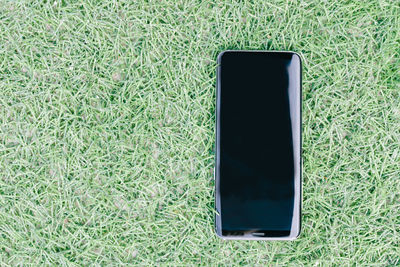 High angle view of smart phone on field