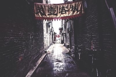 Walkway amidst buildings against sky